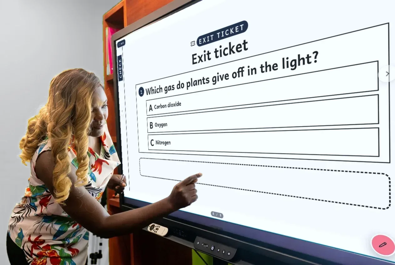 A teacher in Cameroon pointing to an aime exit ticket on the classroom panel